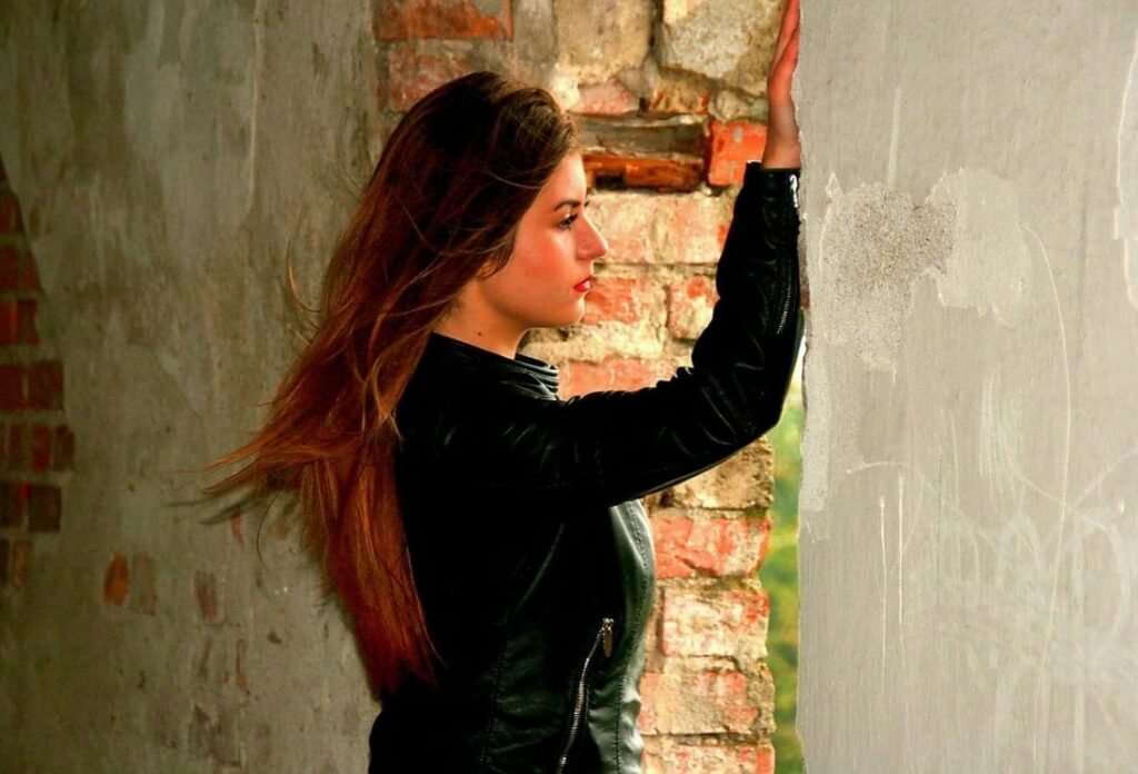 Frau blickt nachdenklich aus dem Fenster, in dem Bewusstsein ich funktioniere nur noch, lebe aber nicht. Etwas passt nicht mehr im Leben.